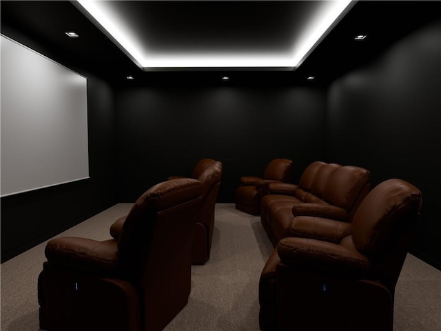 carpeted cinema with a raised ceiling