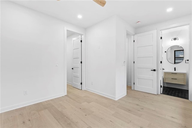 unfurnished bedroom with recessed lighting, light wood-type flooring, baseboards, and ensuite bathroom