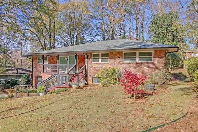 view of front of home with brick siding, a front lawn, and stairs