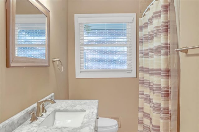 bathroom featuring toilet, visible vents, vanity, and a shower with curtain