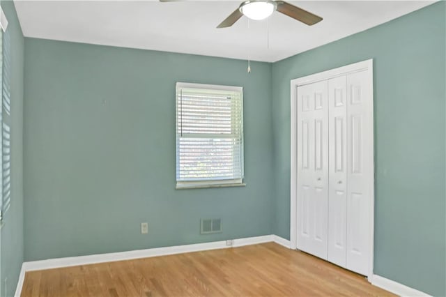 unfurnished bedroom featuring baseboards, a closet, and wood finished floors