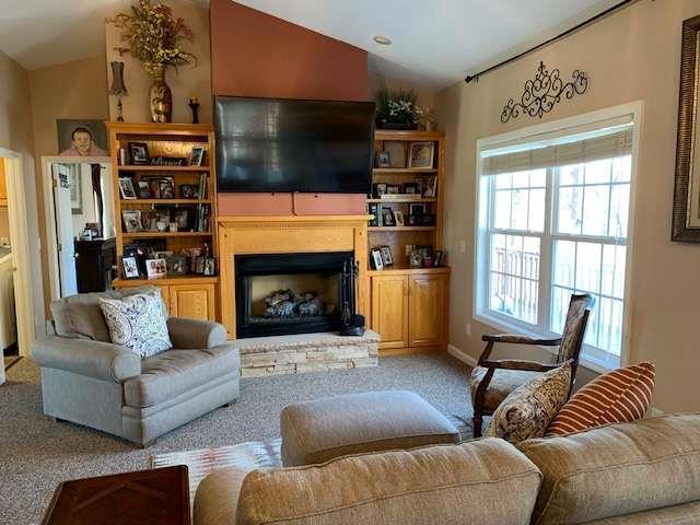 789 N Falling Waters Dr N, Demorest, GA 30535 - carpeted living room featuring vaulted ceiling and a fireplace with raised hearth