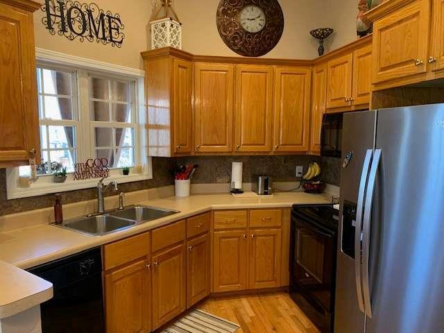 789 N Falling Waters Dr N, Demorest, GA 30535 - kitchen with black appliances, a sink, light countertops, brown cabinets, and backsplash