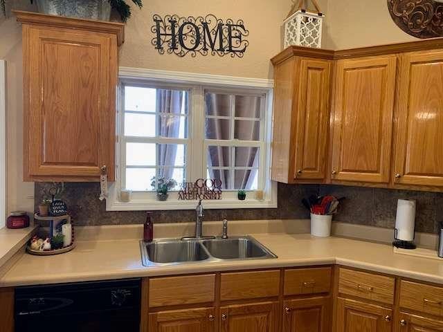789 N Falling Waters Dr N, Demorest, GA 30535 - kitchen featuring black dishwasher, a sink, light countertops, brown cabinets, and backsplash