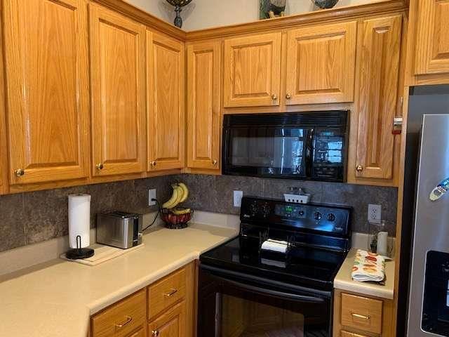 789 N Falling Waters Dr N, Demorest, GA 30535 - kitchen featuring black appliances, decorative backsplash, light countertops, and brown cabinetry