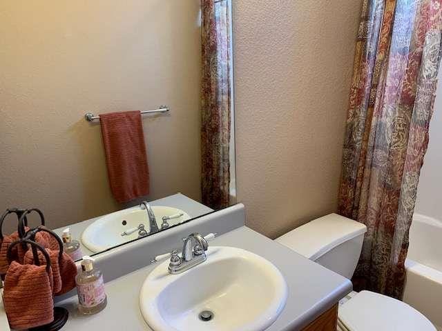 789 N Falling Waters Dr N, Demorest, GA 30535 - full bath featuring vanity, toilet, a textured wall, and shower / tub combo with curtain