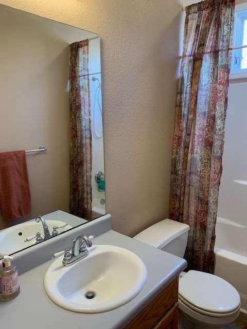 789 N Falling Waters Dr N, Demorest, GA 30535 - full bath featuring vanity, toilet, shower / bathtub combination with curtain, and a textured wall