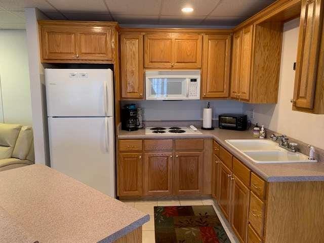 789 N Falling Waters Dr N, Demorest, GA 30535 - kitchen with white appliances, a sink, light countertops, brown cabinets, and a drop ceiling