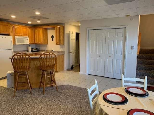 789 N Falling Waters Dr N, Demorest, GA 30535 - kitchen featuring white appliances, brown cabinets, a breakfast bar area, a kitchen island, and light tile patterned floors