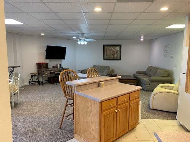 789 N Falling Waters Dr N, Demorest, GA 30535 - kitchen with open floor plan, ceiling fan, light countertops, a kitchen bar, and a paneled ceiling
