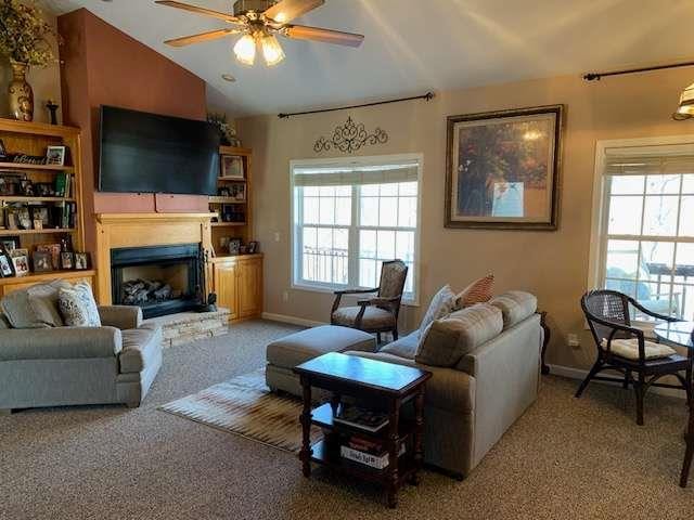 789 N Falling Waters Dr N, Demorest, GA 30535 - living room featuring carpet flooring, vaulted ceiling, a ceiling fan, a fireplace with raised hearth, and baseboards