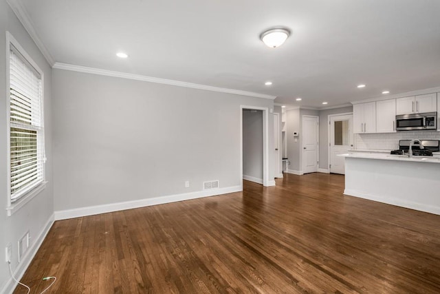 unfurnished living room with dark wood-style floors, baseboards, and crown molding