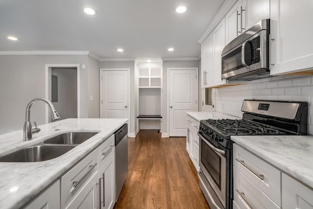 kitchen featuring white cabinets, ornamental molding, stainless steel appliances, and a sink