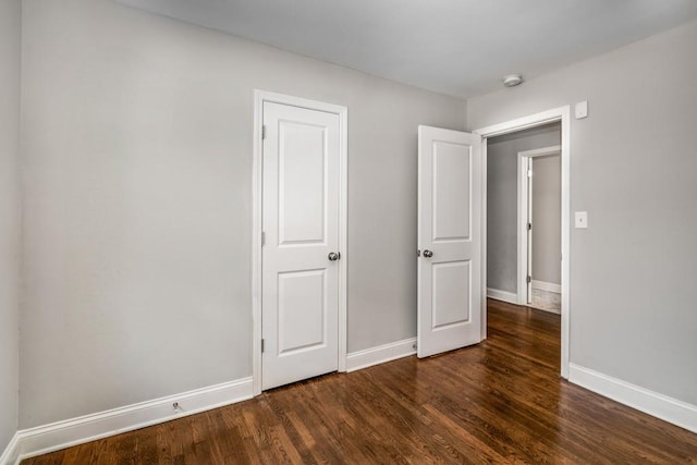 unfurnished bedroom featuring dark wood finished floors and baseboards