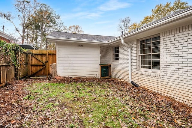 exterior space featuring fence and brick siding