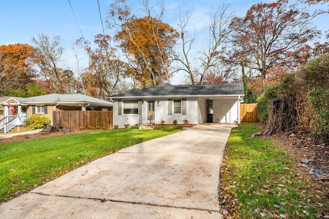 view of front of property with a front yard, brick siding, fence, and driveway