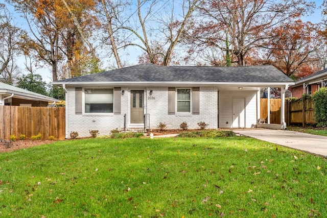 view of front facade with concrete driveway, brick siding, a front lawn, and fence