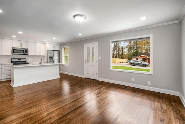 kitchen with tasteful backsplash, dark wood finished floors, stainless steel appliances, crown molding, and light countertops