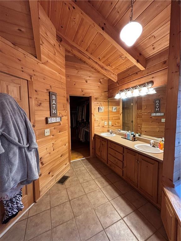 bathroom with tile patterned floors, lofted ceiling with beams, wooden ceiling, vanity, and wooden walls