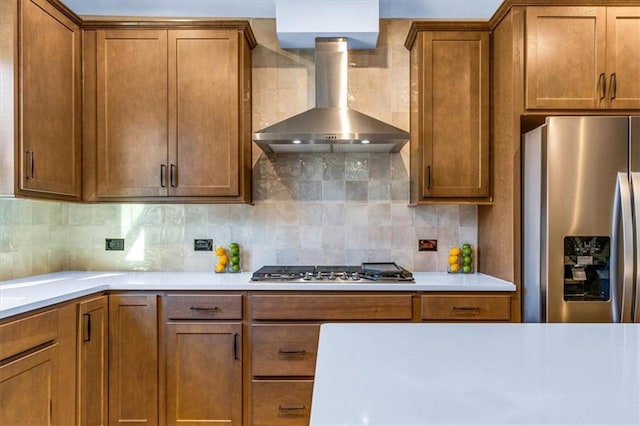 kitchen featuring wall chimney exhaust hood, stainless steel appliances, and tasteful backsplash