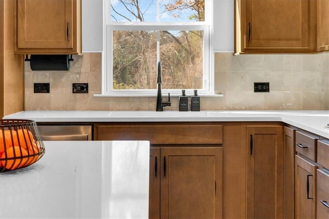 kitchen with tasteful backsplash, sink, and stainless steel dishwasher