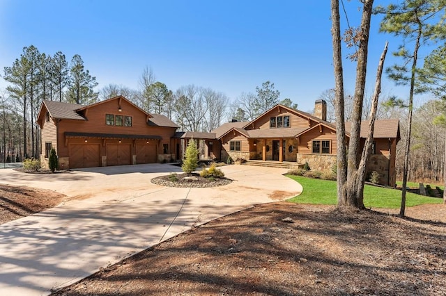 rustic home featuring driveway, stone siding, a garage, and a chimney