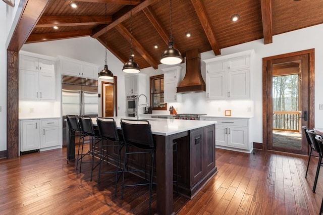 975 Blalock Lakes Dr, Newnan, GA 30263 - kitchen featuring dark wood-style floors, light countertops, a spacious island, and custom exhaust hood