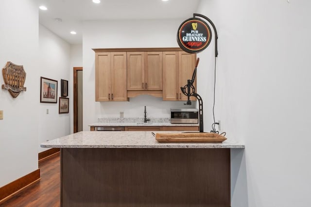 975 Blalock Lakes Dr, Newnan, GA 30263 - kitchen featuring baseboards, light stone counters, dark wood-style flooring, a peninsula, and recessed lighting