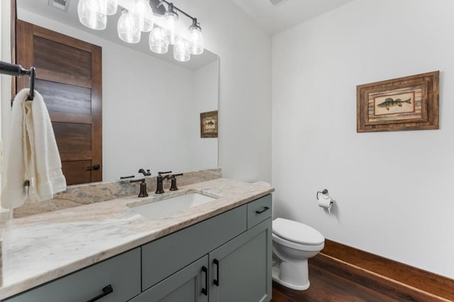 975 Blalock Lakes Dr, Newnan, GA 30263 - half bathroom featuring vanity, wood finished floors, toilet, and baseboards