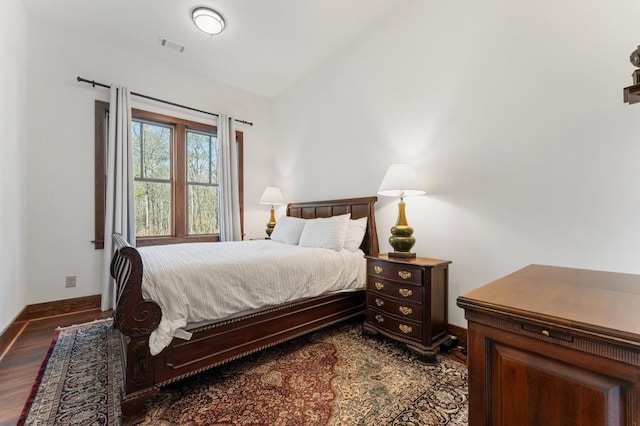 975 Blalock Lakes Dr, Newnan, GA 30263 - bedroom with lofted ceiling, visible vents, baseboards, and dark wood-style flooring