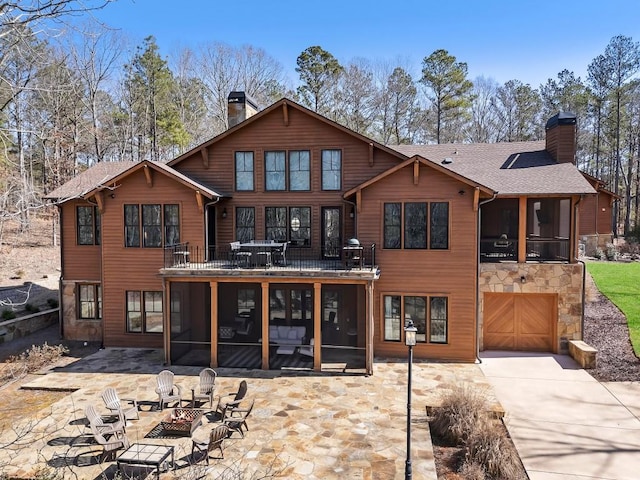 975 Blalock Lakes Dr, Newnan, GA 30263 - back of property featuring a fire pit, a sunroom, and a chimney