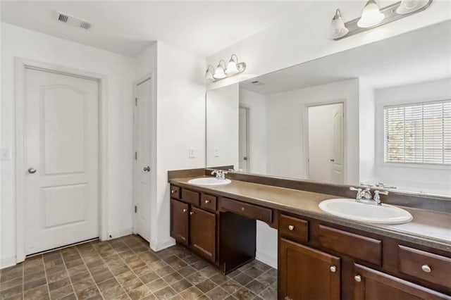 bathroom with double vanity, visible vents, a sink, and a bath