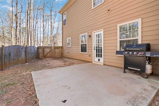 view of patio featuring a grill, a gate, and fence