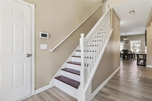 staircase featuring wood finished floors and baseboards