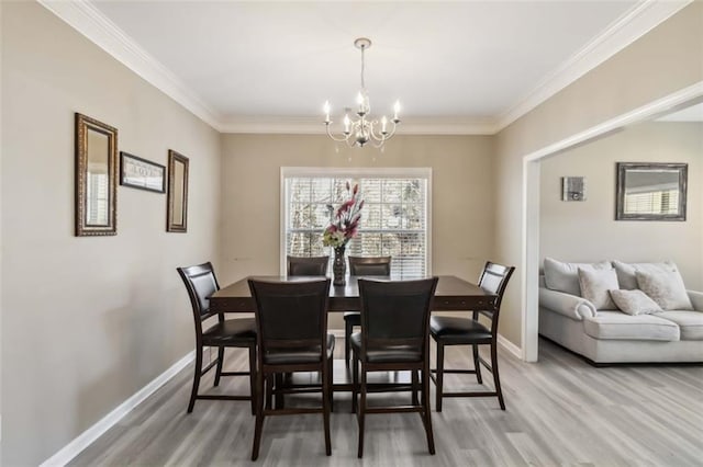 dining space with ornamental molding, a notable chandelier, and baseboards