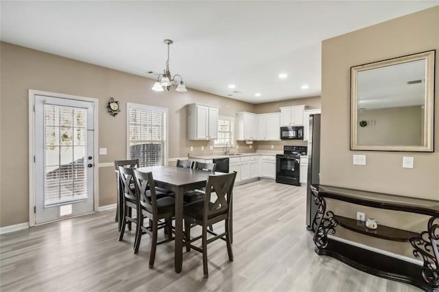 dining room featuring light wood-type flooring, baseboards, a notable chandelier, and recessed lighting