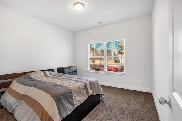 bedroom featuring visible vents, baseboards, and carpet