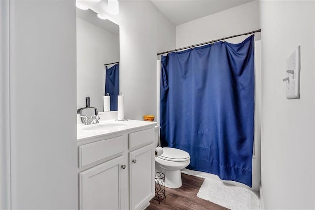 bathroom with vanity, curtained shower, toilet, and wood finished floors