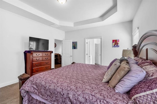 bedroom featuring a raised ceiling, carpet flooring, and baseboards