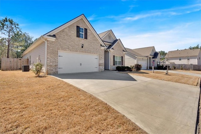 traditional home with driveway, central AC, fence, a residential view, and brick siding