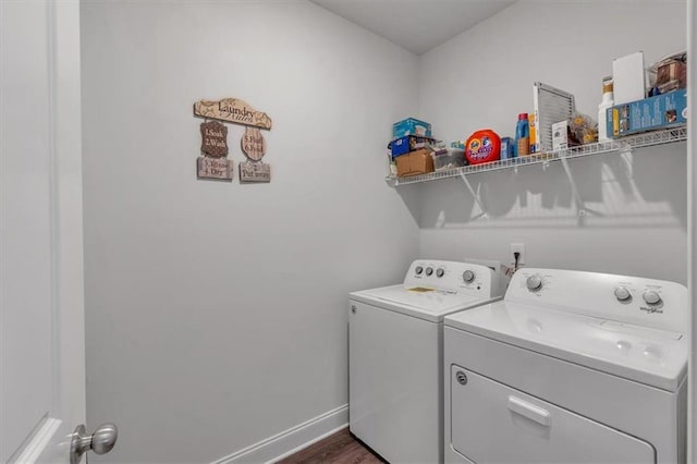 laundry room with dark wood finished floors, laundry area, separate washer and dryer, and baseboards