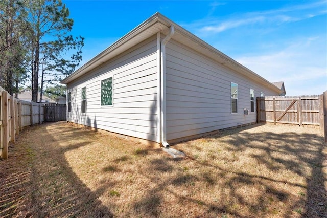 view of side of home featuring a lawn and a fenced backyard