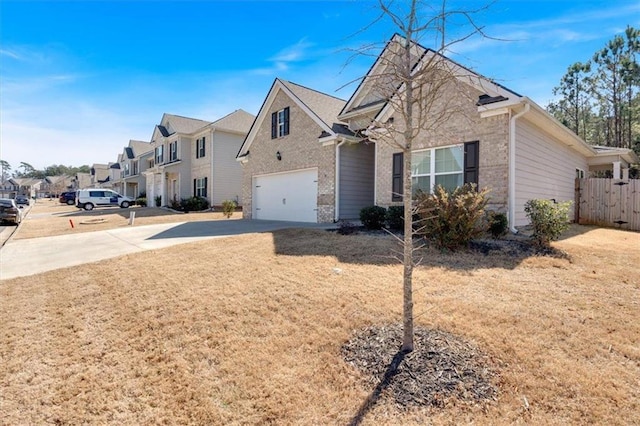 view of front of house featuring fence, a residential view, concrete driveway, an attached garage, and brick siding