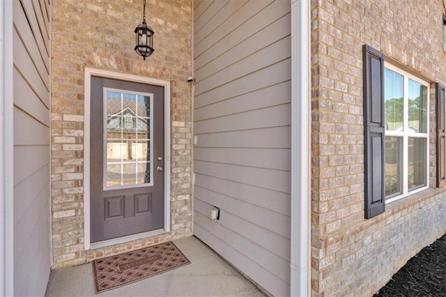 doorway to property featuring brick siding