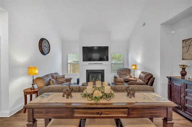 living room with lofted ceiling, visible vents, and a wealth of natural light