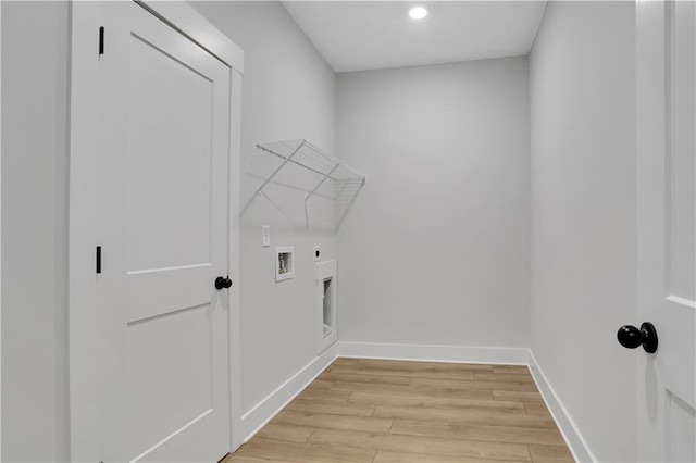 laundry area featuring electric dryer hookup, hookup for a washing machine, and light hardwood / wood-style floors