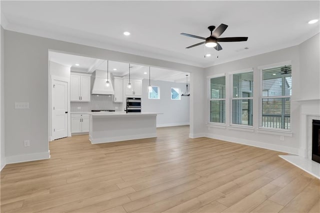 unfurnished living room with ceiling fan and light hardwood / wood-style floors