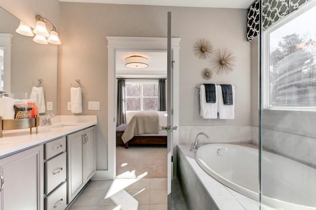 bathroom featuring vanity, a relaxing tiled tub, and tile patterned flooring