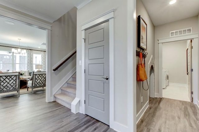 hall with a notable chandelier and light hardwood / wood-style floors