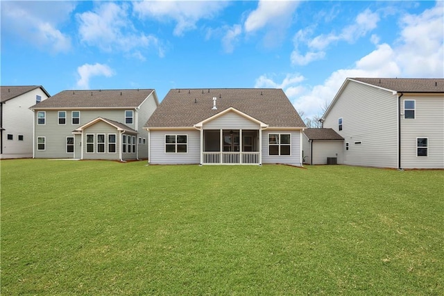 rear view of house with a sunroom, central AC, and a lawn